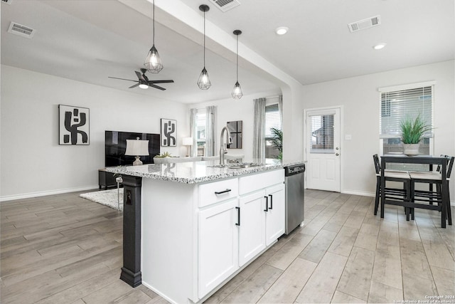 kitchen with stainless steel dishwasher, pendant lighting, a center island with sink, and white cabinetry