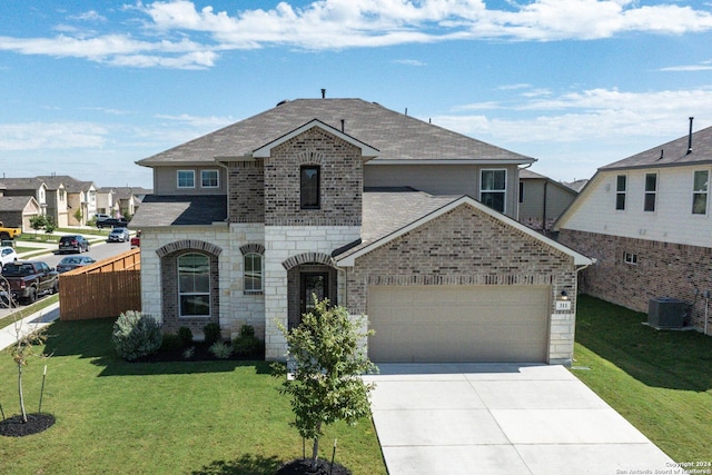 view of front of home with a front lawn, a garage, and central AC