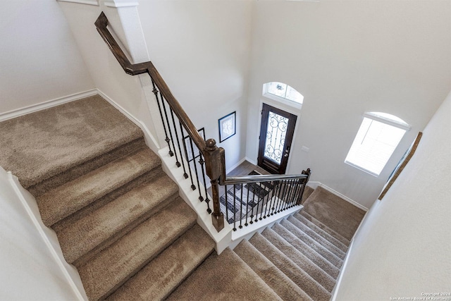 carpeted foyer featuring a high ceiling