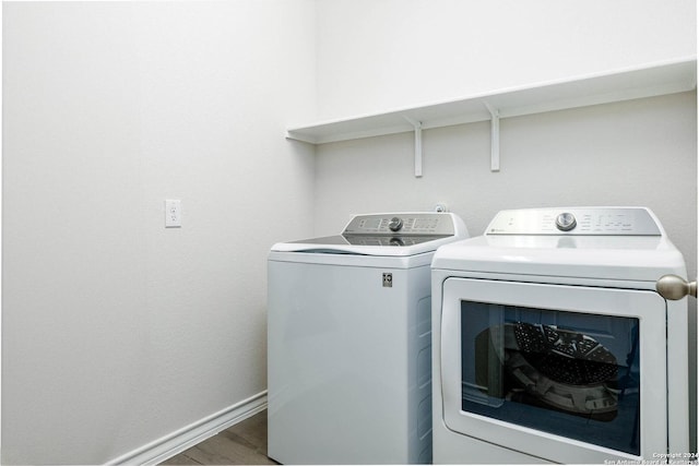 washroom with independent washer and dryer and hardwood / wood-style floors