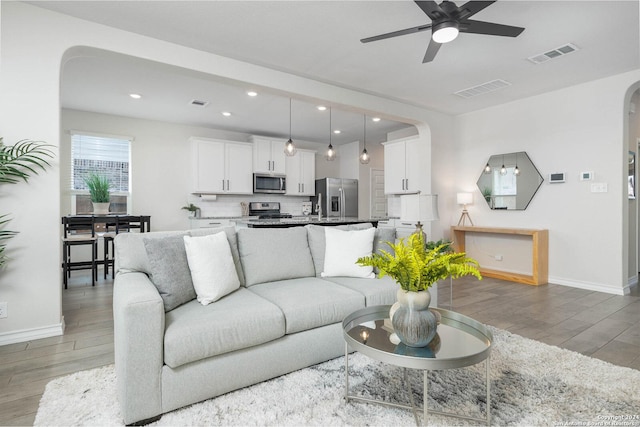 living room with light hardwood / wood-style floors and ceiling fan