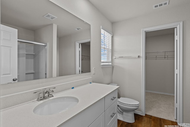 bathroom featuring vanity, toilet, an enclosed shower, and wood-type flooring