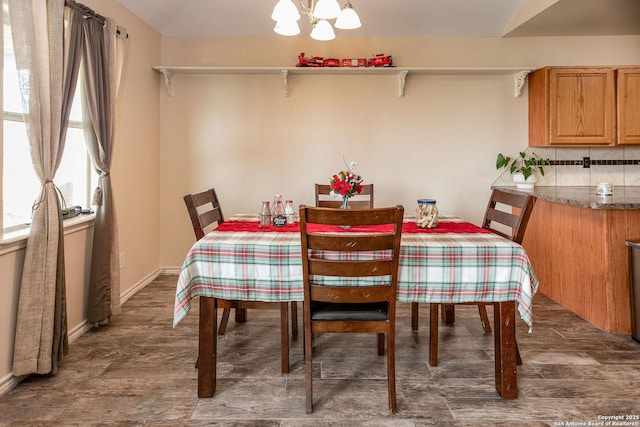 dining area featuring dark wood-type flooring and a notable chandelier