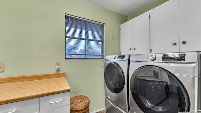 clothes washing area with cabinets and washer and clothes dryer