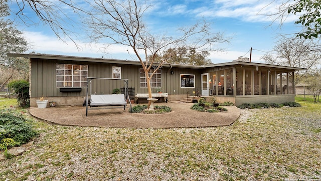 back of property with a sunroom and a patio