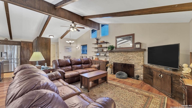 living room with vaulted ceiling with beams, a stone fireplace, wood-type flooring, and ceiling fan with notable chandelier