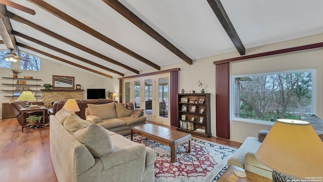 living room featuring lofted ceiling with beams, ceiling fan, french doors, and wood-type flooring