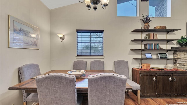 dining space featuring a chandelier, light hardwood / wood-style floors, and lofted ceiling