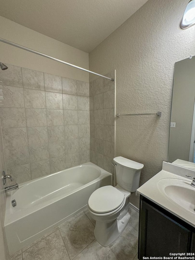 full bathroom featuring toilet, vanity, a textured ceiling, and tiled shower / bath