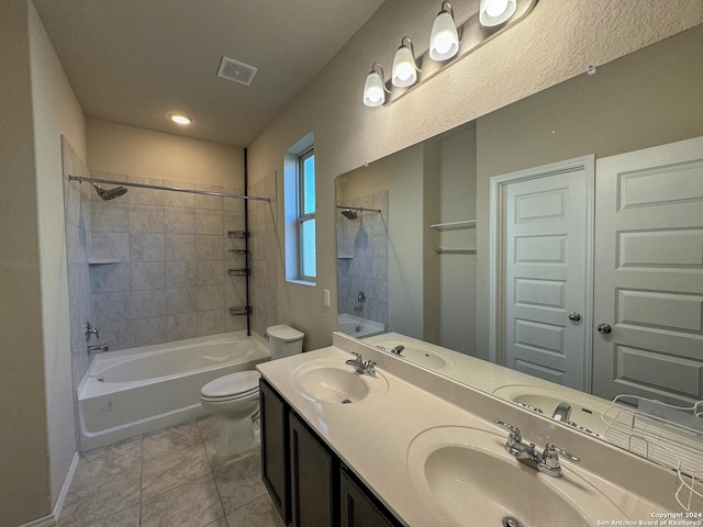 full bathroom featuring tile patterned floors, vanity, toilet, and tiled shower / bath