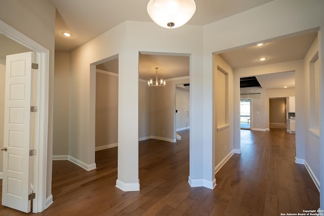 hall with dark hardwood / wood-style floors and an inviting chandelier