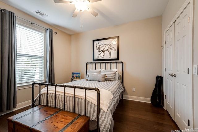 bedroom featuring dark wood-type flooring, ceiling fan, and a closet