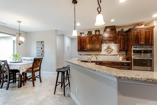 kitchen featuring backsplash, black electric stovetop, light stone countertops, custom range hood, and stainless steel double oven