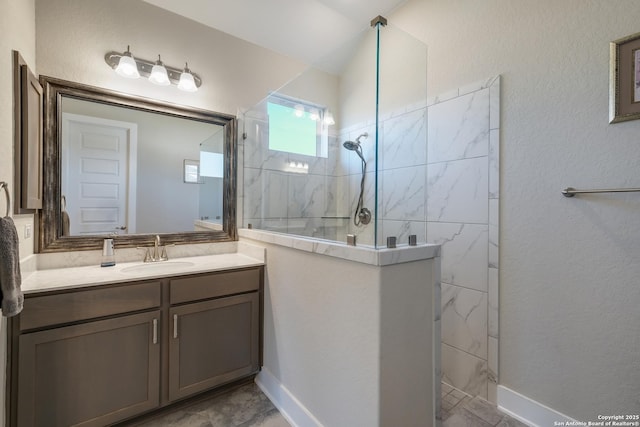 bathroom with tiled shower and vanity