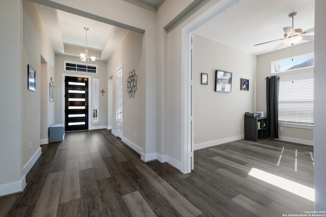 foyer featuring a tray ceiling, dark hardwood / wood-style flooring, and ceiling fan with notable chandelier