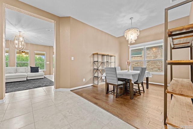 dining space featuring light hardwood / wood-style floors and a notable chandelier