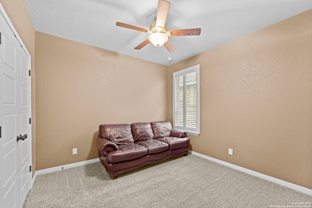 living area featuring carpet flooring and ceiling fan