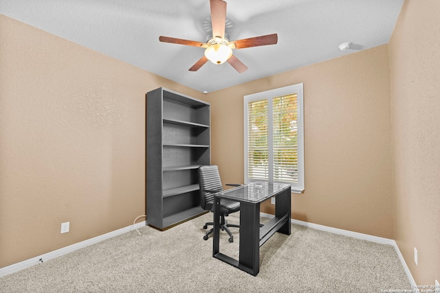 carpeted home office featuring ceiling fan