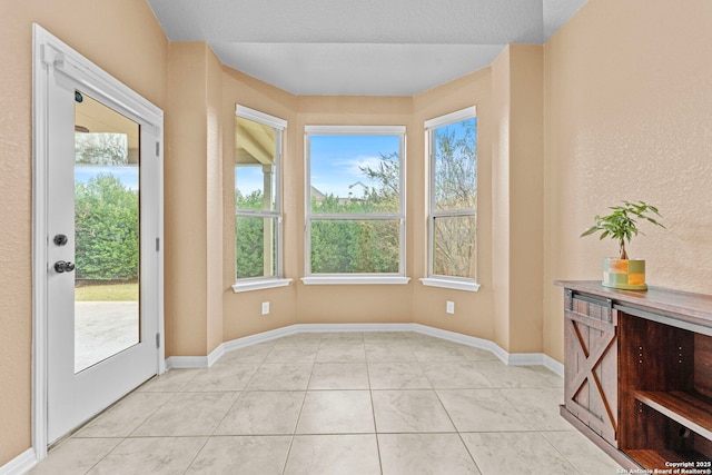 entryway with a healthy amount of sunlight and light tile patterned flooring