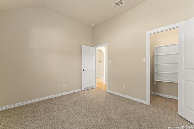 unfurnished bedroom with light carpet, a closet, and vaulted ceiling