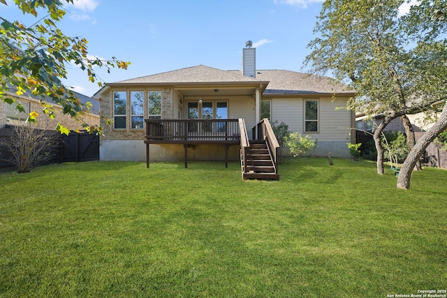 rear view of house featuring a lawn and a deck