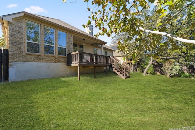 rear view of house with a deck and a yard