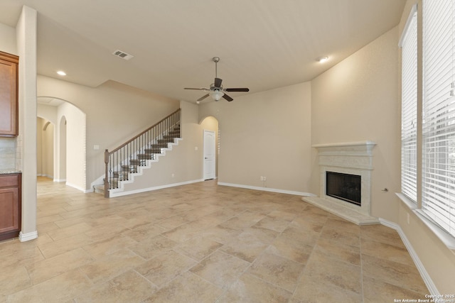 unfurnished living room with ceiling fan and a fireplace