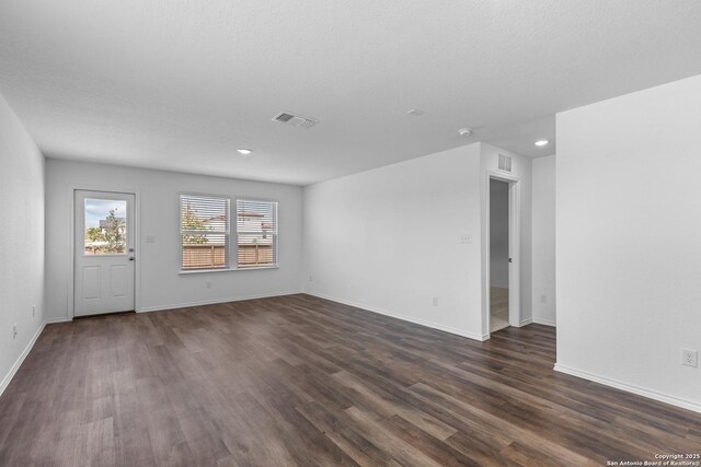 unfurnished living room with dark wood-type flooring