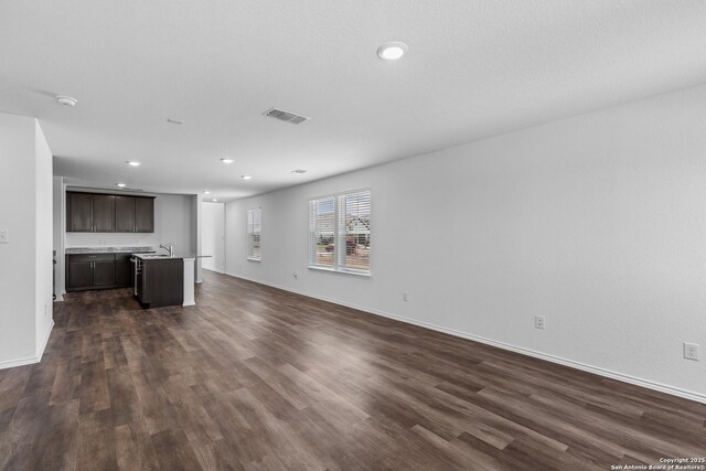 unfurnished living room featuring dark hardwood / wood-style floors and sink