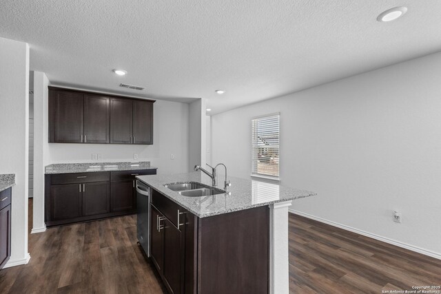 kitchen featuring dishwasher, dark brown cabinets, a kitchen island with sink, and sink