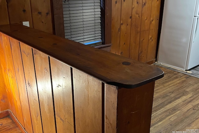 room details with white refrigerator and hardwood / wood-style flooring