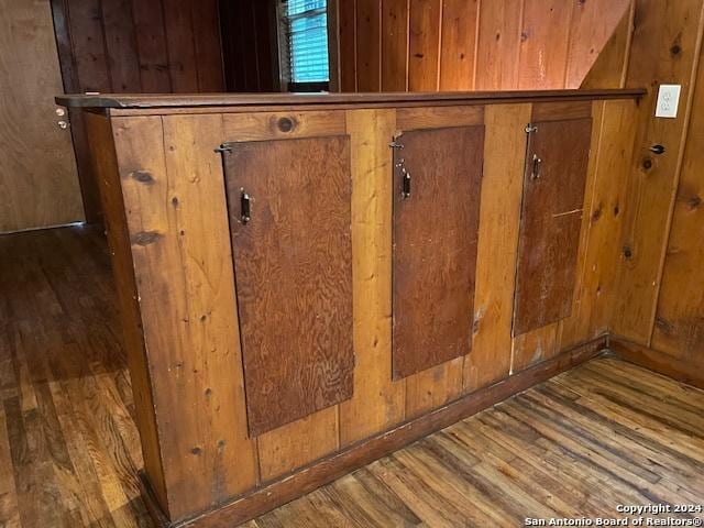 details with wood-type flooring and wood walls