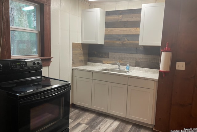 kitchen with sink, electric range, white cabinets, and dark hardwood / wood-style floors