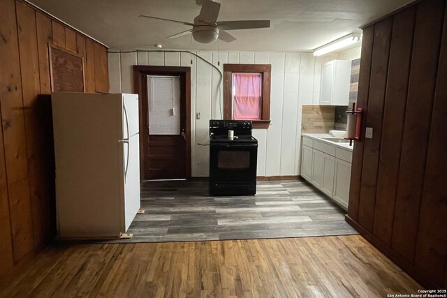 kitchen with light hardwood / wood-style flooring, ceiling fan, white cabinetry, black range with electric cooktop, and white fridge