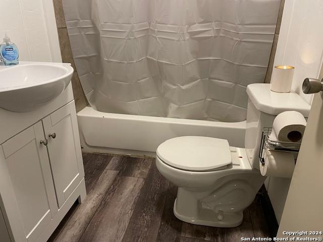 bathroom with wood-type flooring, toilet, and vanity