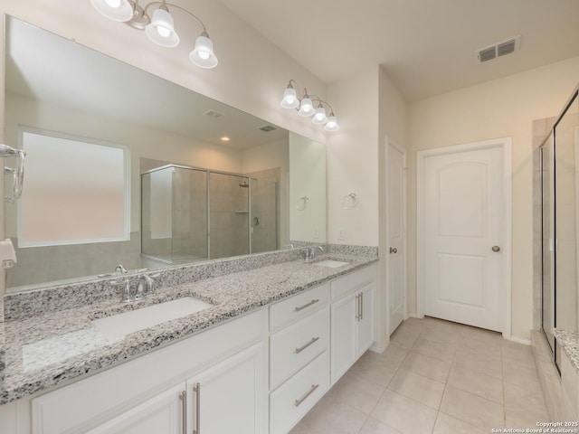 bathroom with tile patterned floors, vanity, and walk in shower