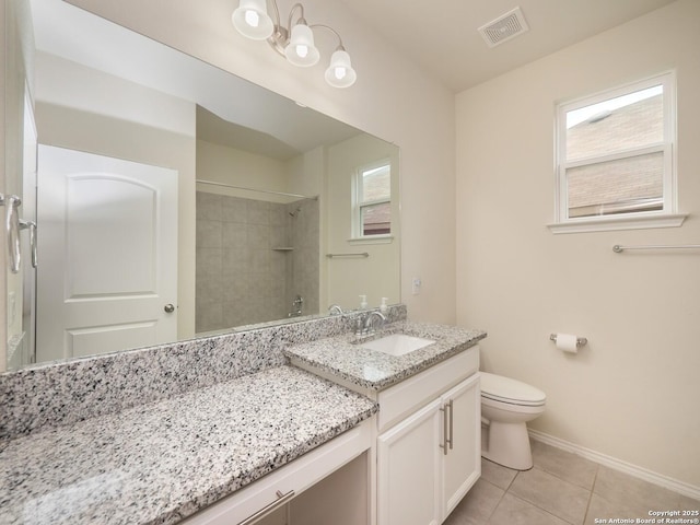 bathroom with tile patterned floors, vanity, a tile shower, and toilet