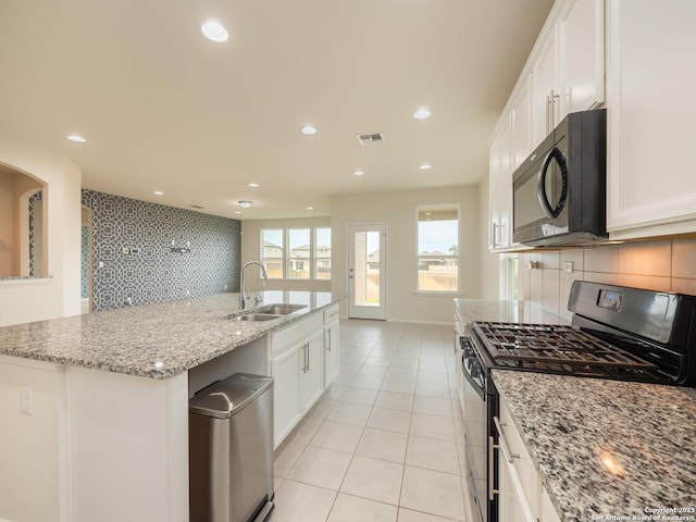 kitchen featuring white cabinetry, sink, an island with sink, and black appliances