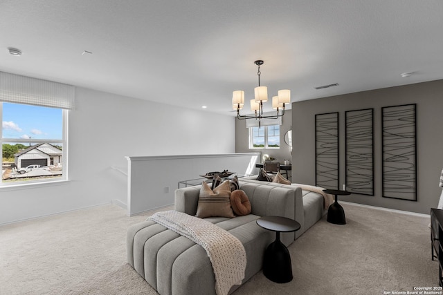 carpeted living room featuring a notable chandelier