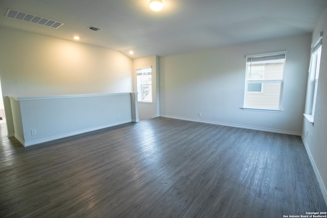 unfurnished room featuring dark hardwood / wood-style flooring and vaulted ceiling