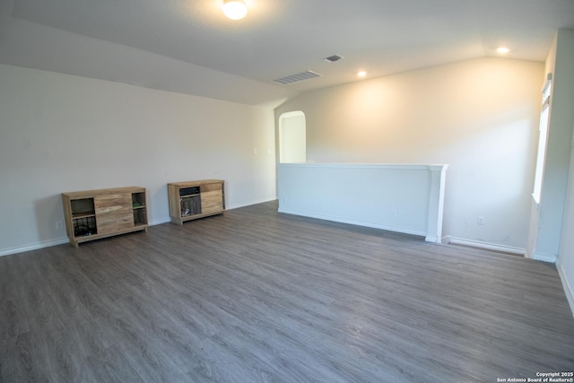 unfurnished room featuring dark hardwood / wood-style floors and vaulted ceiling