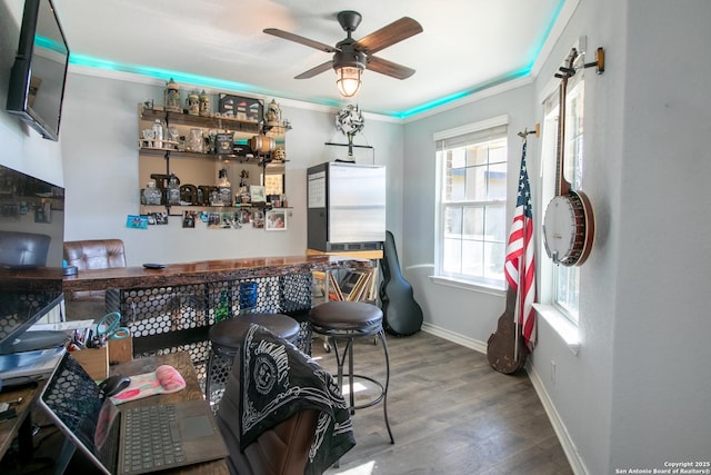 interior space featuring wood-type flooring, ceiling fan, and crown molding