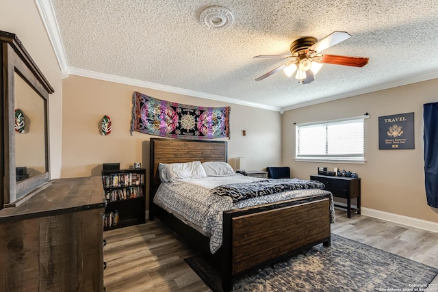 bedroom with ceiling fan, hardwood / wood-style floors, a textured ceiling, and ornamental molding