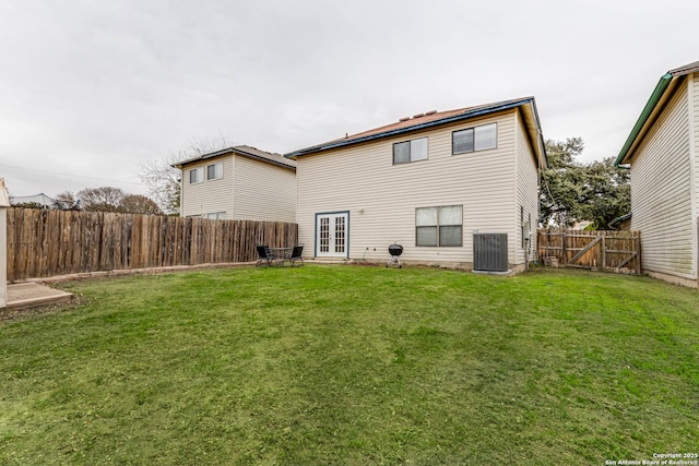 back of house featuring a lawn, cooling unit, and french doors