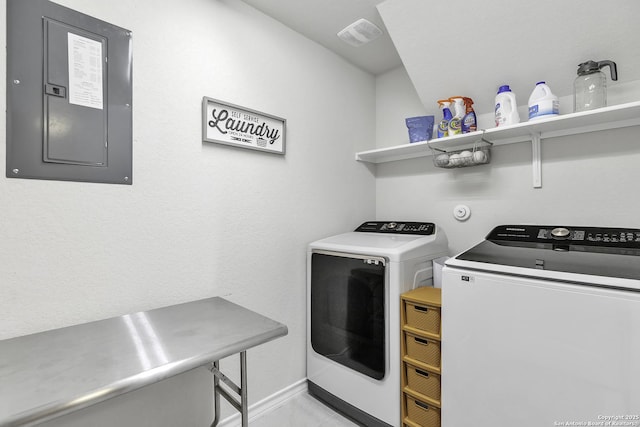 washroom with electric panel and washer and clothes dryer