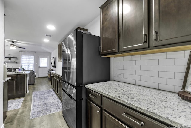 kitchen with ceiling fan, tasteful backsplash, stainless steel fridge, light hardwood / wood-style floors, and dark brown cabinets