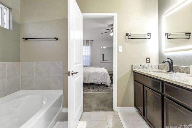 bathroom with tile patterned floors, ceiling fan, a bathtub, and vanity