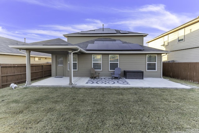 back of property with a lawn and a patio area