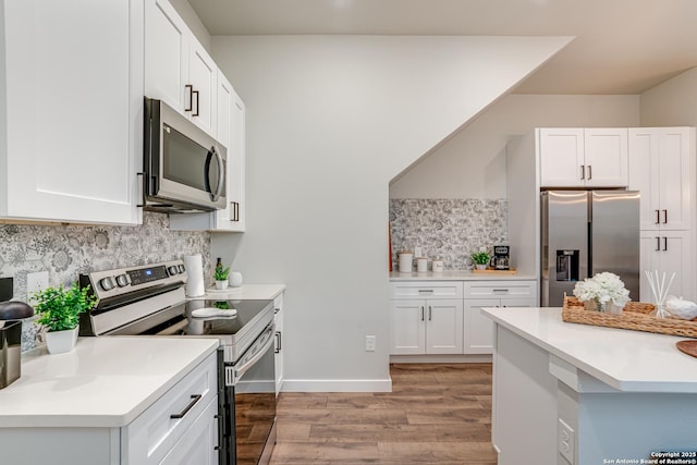 kitchen featuring light hardwood / wood-style floors, white cabinetry, backsplash, and appliances with stainless steel finishes