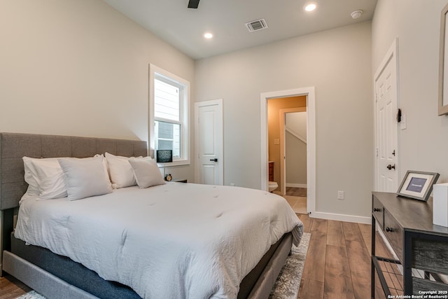 bedroom with hardwood / wood-style floors, ceiling fan, and connected bathroom